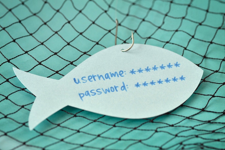 Username and password written on a paper note in the shape of a fish attached to a hook - new phishing scams concept